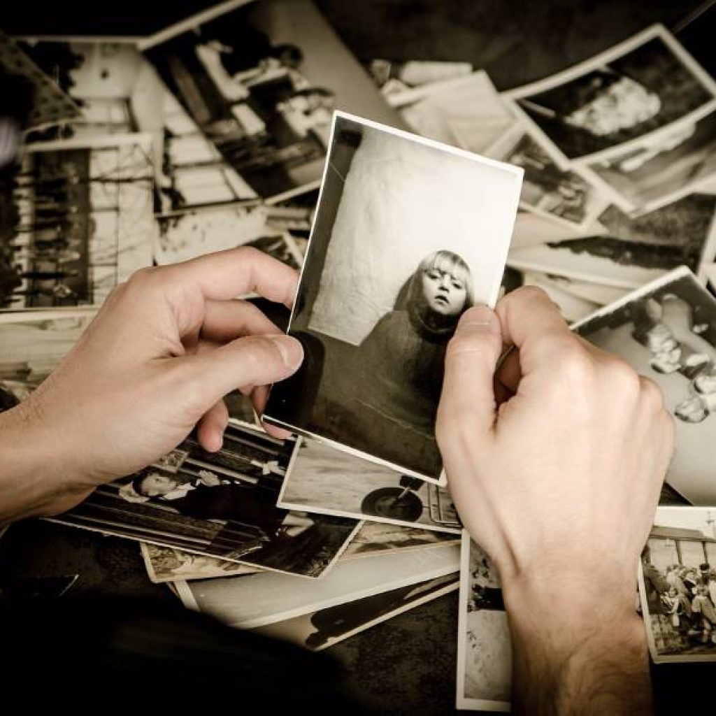 Narrative Counseling: person looking through old photos.